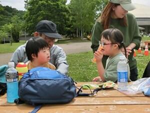 小学部生がベンチに座っておやつ交換をしている様子